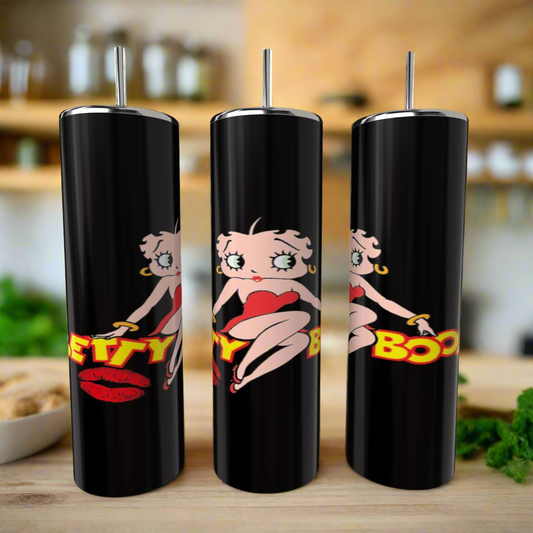 Three black Kreative Kreationz Betty B 20oz Skinny Tumblers with metal straws feature a cartoon woman in a red dress and bold "Betty Boop" text, displayed on a kitchen counter with a blurred background.