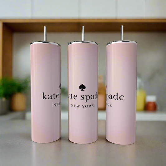 Three pale pink Kreative Kreationz Minimalist Skinny Tumblers with metal straws stand on a kitchen counter, each featuring elegant black lettering. The softly blurred background highlights the tumblers' sleek design.