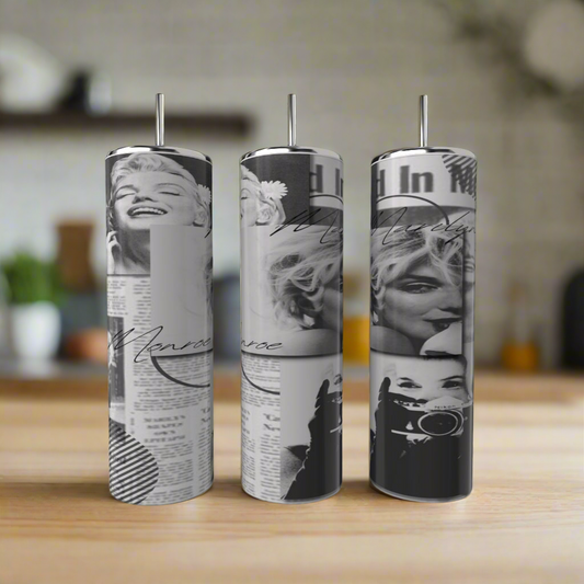 Three Kreative Kreationz Marilyn Monroe 20oz Skinny Tumblers with straws stand on a wooden surface, each displaying black-and-white images, newspaper clippings, and cursive text, glowing against a softly blurred background.