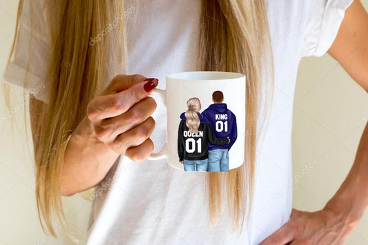 A woman with long blonde hair in a white shirt holds a Kreative Kreationz King & Queen Couples Ceramic Mug, featuring a back-view illustration of a couple in matching "KING 01" and "QUEEN 01" jackets—a thoughtful gift for any pair.