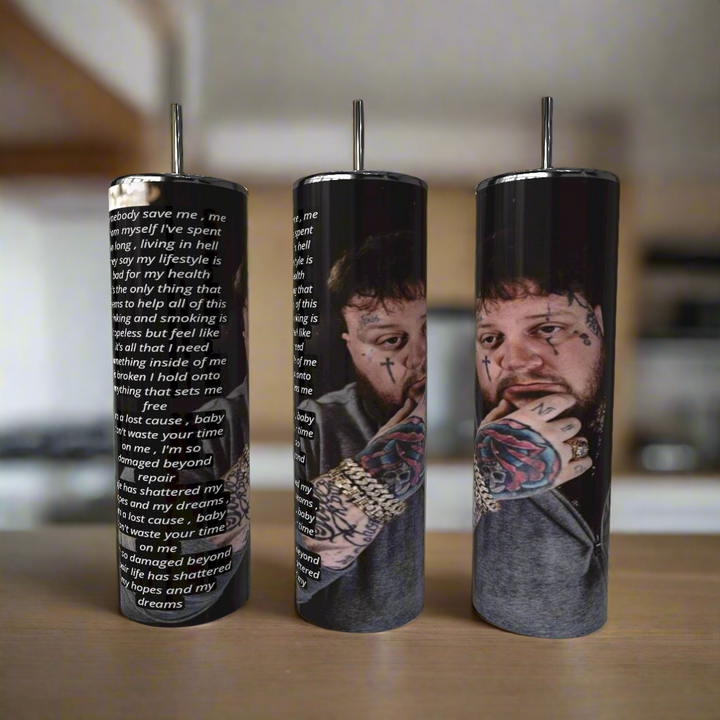 Three cylindrical cups with artistic designs and text on a wooden surface.