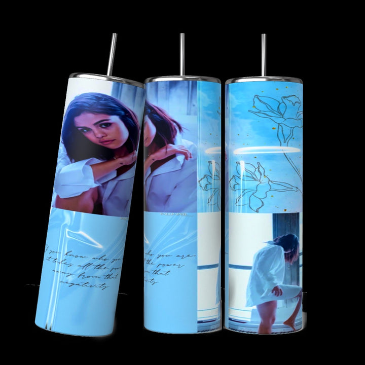 The Kreative Kreationz Selena Gomez Blue Collage 20oz Stainless Steel Tumbler features a woman in a white shirt by a window, blue backgrounds, floral line art, and cursive text—an eco-friendly drinkware choice.