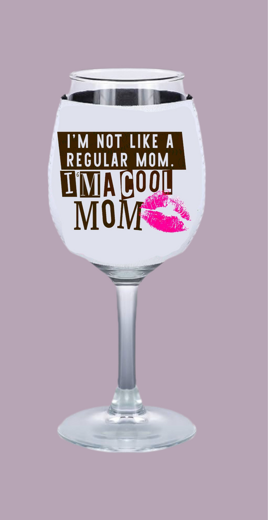 The Kreative Kreationz "Cool Mom - Wine Glass Koozie - Mean Girls" features a neoprene sleeve on a wine glass with "I'M NOT LIKE A REGULAR MOM. I'M A COOL MOM" in brown and white text, a pink lipstick kiss, on a light purple background.
