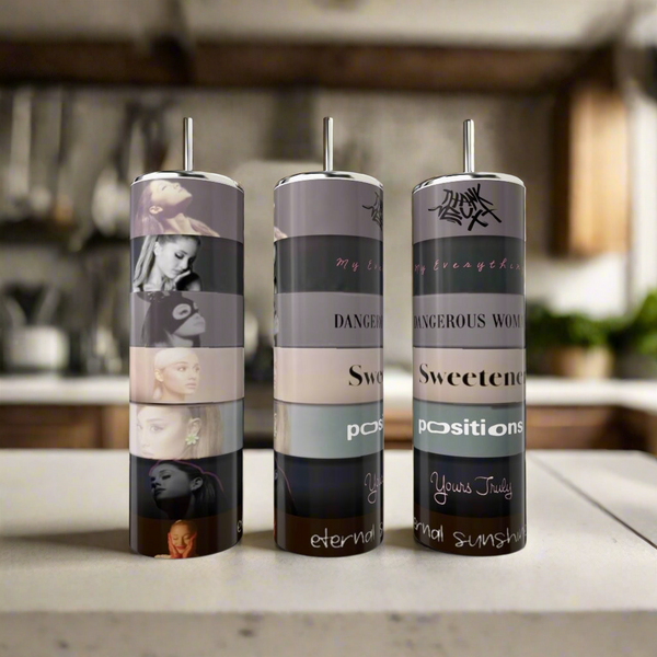 Three Kreative Kreationz 20oz Ariana Grande Album Aesthetic tumblers, each featuring images of a woman and album-inspired designs with references to “Dangerous Woman,” “Sweetener,” and “Positions,” on a kitchen counter.