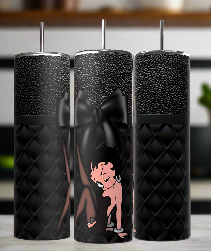Three black quilted Kreative Kreationz "Betty B 20oz Tumbler" drinkware are shown, each with a silver straw. The center stainless steel tumbler is decorated with a large black bow and Betty Boop in her pink outfit and short black hair.