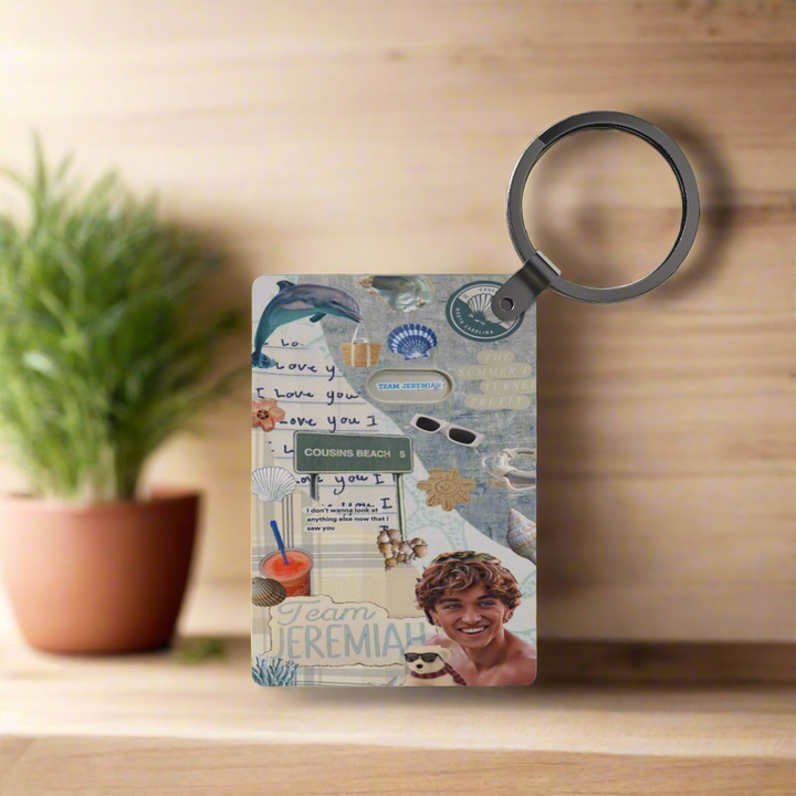 The Team Jeremiah Inspired Keychain by Kreative Kreationz features seaside elements—sunglasses, seashells, “Team Jeremiah”—set at Cousins Beach with a smiling young man, “I love you” notes, and a potted plant on wood.