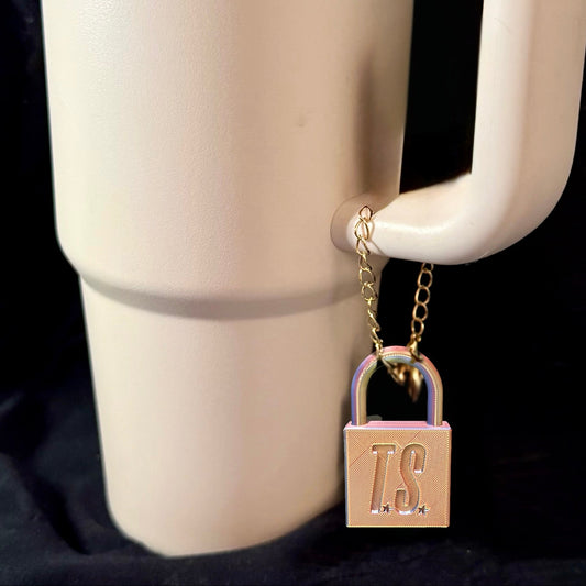 White Stanley mug with a gold padlock charm on a black background