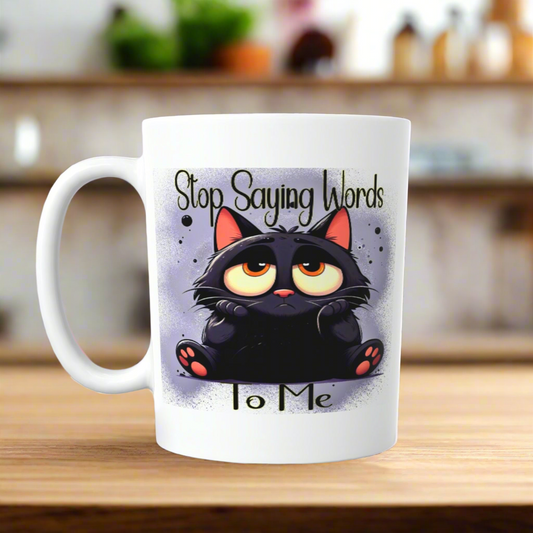 The Cat Sarcastic Ceramic Mug by Kreative Kreationz features a grumpy black cat and "Stop Saying Words To Me" text, making a unique cat lover gift for any kitchen counter.