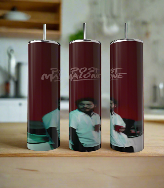 On a wooden surface are three tall cylindrical tumblers of the Kreative Kreationz brand, from the "Post Malone | Red | Tumbler" line. These luxury-inspired reflective dark red stainless steel tumblers display a blurry image of a person in a white shirt against a blurred kitchen background, with text near the top.