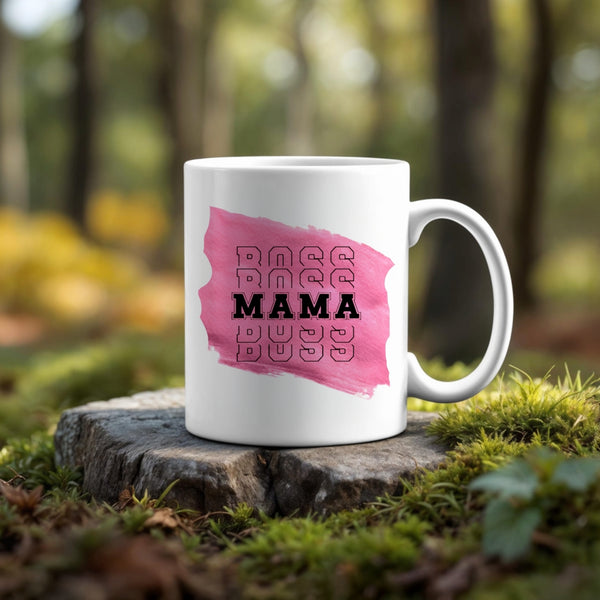 The Mama Mug by Kreative Kreationz features "BOSS MAMA" over a pink brushstroke. Shown on a tree stump amid forest moss, this ceramic mug is dishwasher safe and blends stylish design with natural scenery.