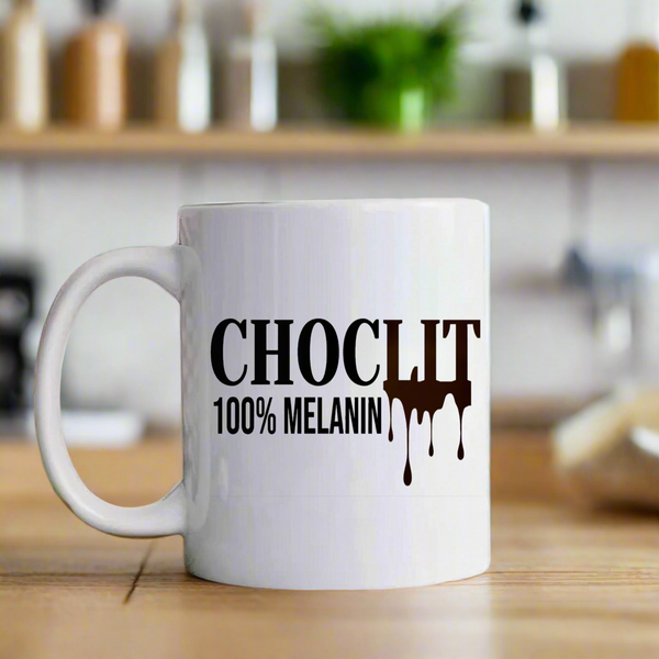 The Choc Lit Mug by Kreative Kreationz features "CHOC LIT 100% MELANIN" with a melting chocolate design on ceramic, set on wood with a blurred kitchen background. Dishwasher safe for easy cleaning.