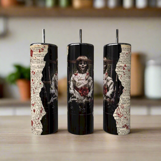 Three cylindrical pepper mills with horror-themed designs on a wooden surface.