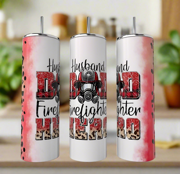 Three Kreative Kreationz Firefighter Dad 20oz Tumblers with lids and straws feature red, black, and leopard prints and "Husband Dad Firefighter Hero" text with a firefighter mask design, set on a kitchen counter.