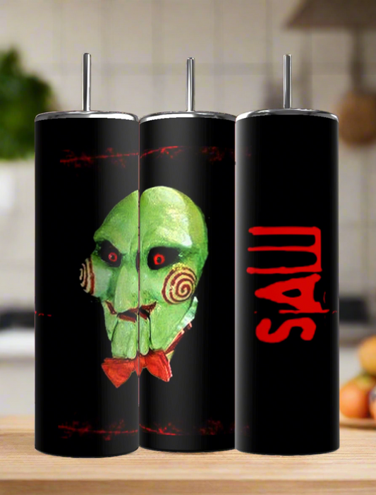 Three Billie The Puppet 20oz Tumblers by Kreative Kreationz are displayed—two with the green SAW puppet face, one with a red "SAW" logo. Eco-friendly drinkware for horror fans, shown on a kitchen counter.