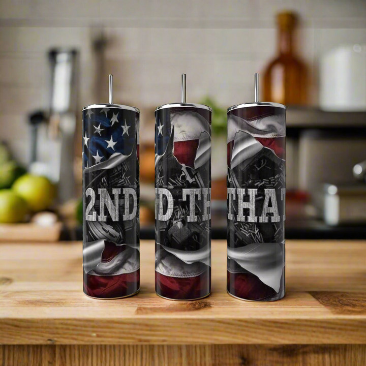 Three Kreative Kreationz 2nd Amendment 20oz Skinny Tumblers with straws sit on a kitchen counter. Each stainless steel tumbler displays bold, distressed white “2ND AMEND THAT” lettering, adding contrast to the modern kitchen setting.