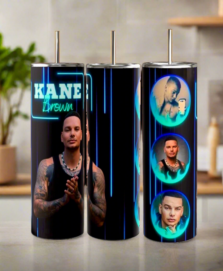Three Kreative Kreationz Kane Brown 20oz Tumblers, featuring a full-body image and circular portraits of the singer on a black and neon blue background, are displayed on a kitchen counter.