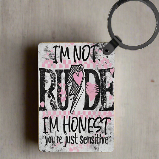 The Im Not Rude Your Sensitive Keychain by Kreative Kreationz features bold black text with pink hearts and a lightning bolt on a distressed white and pink background. Fade-resistant colors ensure it always looks fresh.