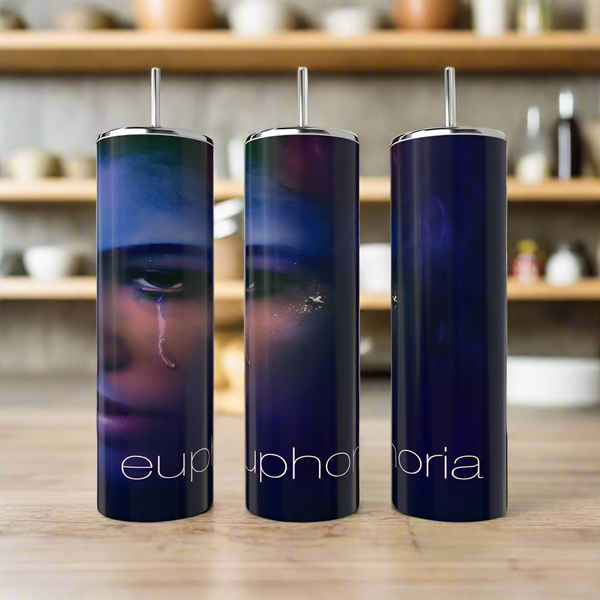 Three tall, dark blue Kreative Kreationz Euphoria Tumblers with stainless steel straws sit on a wooden surface. Each eco-friendly tumbler shows a close-up face with a tear and “euphoria” in white lowercase letters.