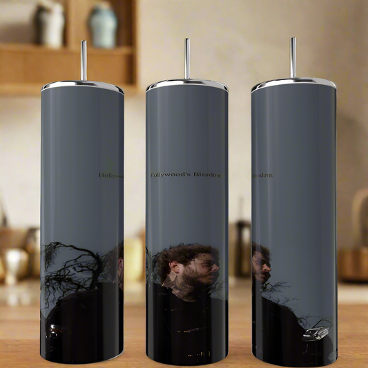 Three tall, luxury Posty Tumblers by Kreative Kreationz sit on a kitchen countertop reflecting an outside scene. Each dark gray tumbler with a metallic lid shows part of a man's face, trees, and sky. Blurred kitchen items linger in the background.