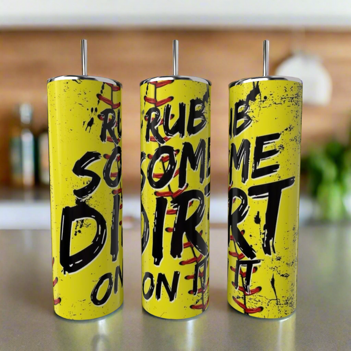 Three tall yellow 20oz "Rub a Little Dirt On It" tumblers by Kreative Kreationz with metal straws and baseball-style red stitching are shown on a counter. Eco-friendly, reusable stainless steel drinkware with distressed black text.