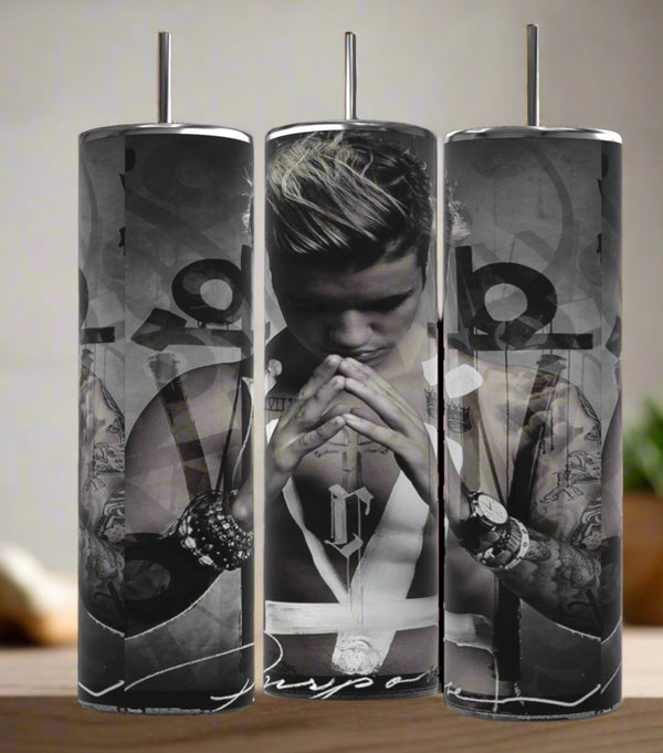 The Kreative Kreationz Justin Bieber Prayer 20oz Tumbler features a black-and-white image of him praying with "Purpose" at the bottom, abstract designs, and a spill-proof lid for convenience.