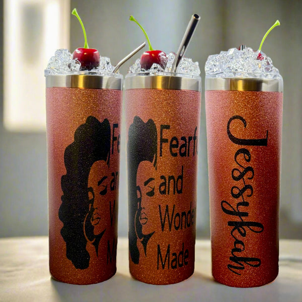 Three glittery orange Kreative Kreationz Custom 20oz Tumblers with ice, cherries, reusable metal straws, and 3D lid toppers. Two feature an illustrated woman with “Fearfully and Wonderfully Made”; the third says “Jessykah.”.