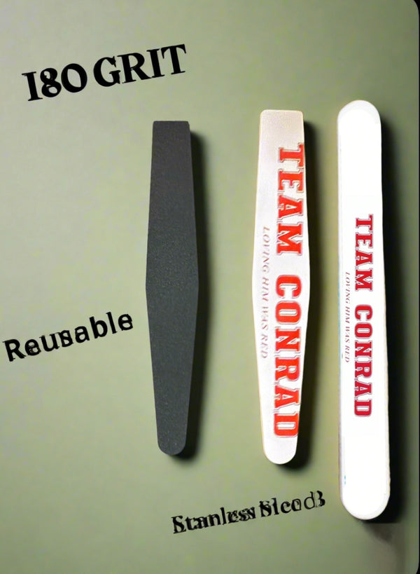 Three Kreative Kreationz Team Conrad Ceramic Nail Files stand vertically on a gray background. The left file is labeled "180 GRIT," while the two white files with red text read "TEAM CONRAD." They feature reusable and stainless block labels.